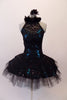 Stunning black sequined lace tutu has a ruffled halter collar neck with a shimmery teal underlay with sweetheart bust. The back has vertical angled straps for support. The bodice and overlay are attached to the six-layer black pleated tutu. Comes with a black floral hair accessory. Front