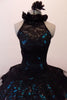 Stunning black sequined lace tutu has a ruffled halter collar neck with a shimmery teal underlay with sweetheart bust. The back has vertical angled straps for support. The bodice and overlay are attached to the six-layer black pleated tutu. Comes with a black floral hair accessory. Front zoomed