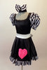 Sweet black dress has black and white striped pouffe sleeves and wide white waistband with large bow at back. The attached skirt has a black and white striped ruffle and a large pink sequined heart.  Comes with matching black and white striped hair bow. Side