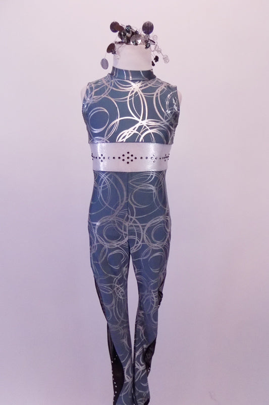 Blue-grey full unitard has silver circle swirls throughout. The outside of each leg has a black sheer inlay with a wave pattern of crystals The deep open back has a wide horizontal silver band embossed with crystal designs. The matching hairpiece is a futuristic wrap of large circle sequins. Front