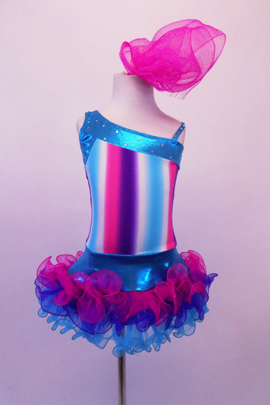 Costume has turquoise, crystal lined neckline with asymmetrical shoulder and straps with an adorable curly ruffled attached skirt in shades of blue pink and purple. The colours of the skirt compliment the striped vertical torso and the large pink hair accessory. Front