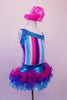 Costume has turquoise, crystal lined neckline with asymmetrical shoulder and straps with an adorable curly ruffled attached skirt in shades of blue pink and purple. The colours of the skirt compliment the striped vertical torso and the large pink hair accessory. Right side