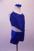 Electric blue metallic look short unitard has crossed back straps and a sequined bust.  The unique asymmetrical cut-out at the right midriff gives the costume its uniqueness. Comes with a blue hair accessory. Right side
