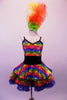 Rainbow coloured dress has black sequined waistband and crystal-lined bustline. The attached skirt has colourful layered, sequin edged ruffles of red, blue and green. Comes with large colourful feather hair accessory. Front