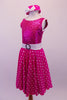 Fuchsia dress has sequined bodice with white crystal lined piping and low scoop back with a bow. The fuchsia and white polka dot skirt has petticoat for volume and a white belt with crystal circle buckle. The matching polka dot pill hat is scattered with crystals and a matching white bow. Side