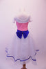 Romantic style ballet dress has pink glitter bodice with white crystal lined bust and cap sleeves. The bust and waist are embossed with royal blue 3-D sequined floral applique and large back bow. The attached white skirt is crystal-tulle with petticoat and trimmed with royal blue ribbon. Comes with a hair accessory. Back