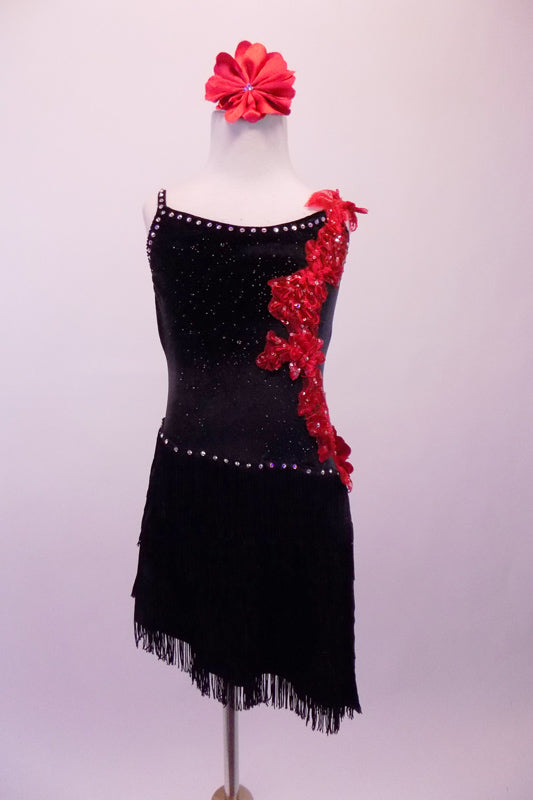 Black sequined dress is lined with crystals along the neckline and straps. The angled skirt is comprised of layers of black fringe lined at the hip by crystals. The left side of the torso from shoulder to hip is covered with a cascade of red 3-D floral sequined appliques. Comes with a red floral hair accessory. Front