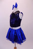 Blue-black costume has a diamond sequin bust with white trim open back and black leatherette crystalled collar. The attached blue skirt with crystal scattered organza overlay has a white belt with crystal buckle. Side