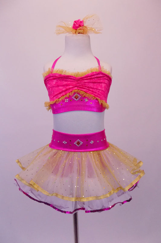 Two-piece costume has bright pink tie-up halter half top with tiny gold tulle ruffling and crystalled design accents at bust and back. The layered white and gold skirt is edged in gold and a purple ribbon with wide pink waistband has a crystal design that compliments the bust. Comes with matching hair accessory. Top