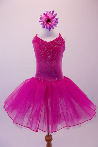 Magenta velvet ballet dress has silver sparkle design within the bodice. The layered tulle skirt has a glitter tulle overlay and cross back straps. Comes with a floral hair accessory. Front