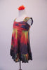 Deep jewel colours of blue red yellow & green combine in a 60s inspired hippie tie-dye style empire waist dress. The gathered bust gives rise to wide shoulder straps & a lower back. The knee length dress has a large ruffle at the bottom. Comes with an orange floral hair accessory. Left side