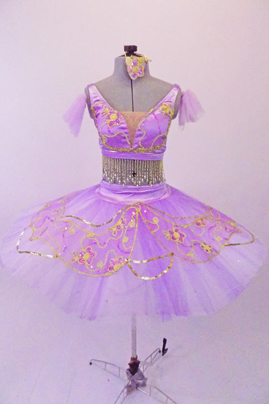 Professional pleated & hand tacked 9-layer pancake two-piece tutu has pale lavender overlay adorned with gold sequin & appliqued flowers. The matching bra-like bodice has hook closure, scoop back & is lined entirely with cascading beaded pearl fringe accent. Comes with lavender tulle armbands and hair accessory. Front