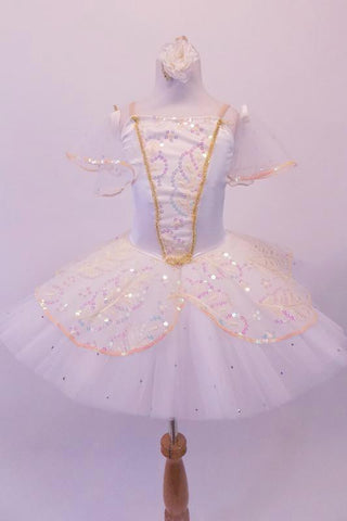 Professional pleated & hand tacked pancake tutu is perfect for the pre-teen ballerina. The white tutu is scattered with crystals & has a cream sequined split overlay with sequined edging. The bodice has a matching sequined V-panel front edged with gold braiding. Comes with lightly ruffled sequined tulle armbands. Front