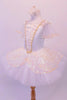 Professional pleated & hand tacked pancake tutu is perfect for the pre-teen ballerina. The white tutu is scattered with crystals & has a cream sequined split overlay with sequined edging. The bodice has a matching sequined V-panel front edged with gold braiding. Comes with lightly ruffled sequined tulle armbands. Side