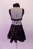 Black semi-sheer leotard dress has antique gold polka dots & is fully lined in the body. The bust is a low deep V with a black lace centre insert. The back is open with a single clip bra closure & the open sides curve into the front torso. The ruched glittery waistband compliments the attached polka dot skirt. Back