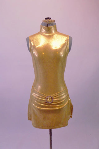 Gold leotard is simple yet stunning. It has a high collar and large open keyhole back. The attached skort-style skirt has side slits and a front gathered waist with crystal buckle accent. Comes with golden hair barrette. Front