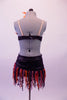 Exotic two-piece costume is a black scale-like bra covered at the front entirely by purple and orange feathers and adjustable nude straps. The matching skirt has an asymmetrical matching black waistband with orange and purple curly finger fringes. Comes with matching feather hair accessory. Back