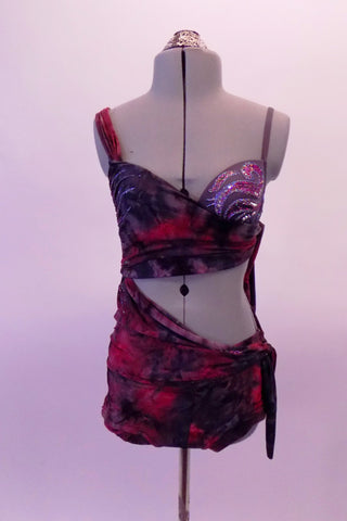 Two-piece costume has a purple, red and grey marbled sarong style half top and skirt as the base. The top crosses over the right bust with silver accents and wraps asymmetrically and ties up at the left back. The left bust reveals a beautiful hand painted purple-grey bra. Front