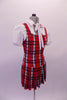 Red white and navy tartan school girl style costume has attached pleated skirt with a built-in brief. The separate white pouffe sleeved blouse has snap front closure and tie front attached to the collar. Side