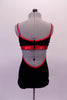 Black leotard has a built-in bra and sides that open to the back. It has bright red metallic binding and straps. Comes with a red floral hair accessory. Back