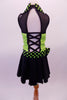 Back and lime green sequined costume has faux sweetheart bust with a black mesh upper and a green and black polka dot collar that matches the waistband and large bow accent. The back is open with corset style straps that hold the torso together. The attached black skirt completes the look. Comes with polka dot gauntlet and hair accessory. Back
