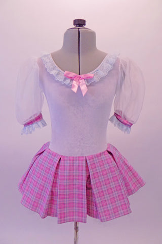Ballet dress has white velvet bodice with large sheer pouffe sleeves and lace trim along neckline. The wide box-pleated skirt is a pale pink tartan that is also accented in the banding of the sleeves. A pink satin bow accents the bodice. Comes with pink bow hair accessory. Front