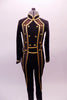 Black military style full unitard has gold piping and button accents. Bronze mesh inlays extend along the sides of the front torso and down the sides of the legs. The gold piping is used to create a faux waistband and cuffs. Front