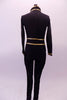 Black military style full unitard has gold piping and button accents. Bronze mesh inlays extend along the sides of the front torso and down the sides of the legs. The gold piping is used to create a faux waistband and cuffs. Back