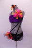 2-piece costume is attached by two crystal covered straps that extend from below the left bust across the front of the torso. The costume is a black base with colourful holographic dotted pattern. The brief has crystalled waistband & an orange-pink tulle accent at hip & the bust of the purple fur covered strappy bra. Left side