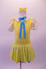 Yellow dress with floral sequin pattern has pouffe sleeves and a white eyelet lace Peter Pan collar. A turquoise ribbon tie highlights the front center at the collar. The attached blue sequin edged petticoat give the dress some volume. Comes with a yellow floral hair accessory. Front