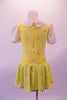 Yellow dress with floral sequin pattern has pouffe sleeves and a white eyelet lace Peter Pan collar. A turquoise ribbon tie highlights the front center at the collar. The attached blue sequin edged petticoat give the dress some volume. Comes with a yellow floral hair accessory. Back