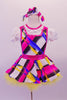Colourful dress with abstract geometric patterns of blue pink yellow & black has a white ruffled collar & pouffe sleeves on a faux white blouse with keyhole back. The dress has hot pink crystalled piping & large pink bow at the back. The yellow tulle petticoat gives the skirt some volume. Comes with matching hair bow. Front