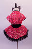 Funky orange and black two-piece costume has a black bodice and tutu skirt. The large mesh sequined orange overlay sits over the tutu skirt and compliments the crystalled orange V at the front of the bodice. An orange mesh shrug completes the look. Comes with a large black, orange sequined hair bow. Back