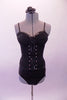 Black boned, zip back, Guess bustier has delicate sequined ruffle along the bustline and down the front center of the hook and eye bustier with crystal accents. The matching Lacey Swimmer brief is a higher cut with leatherette side panels. Comes with a black floral hair accessory. Front