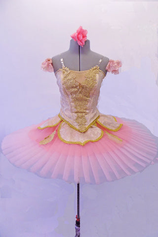 Gold brocade bodice & pink back is covered with gold appliqué & trim work and has crystal detailing all over the bodice and attached overlay. Bodice zips at the back and is double layered. The tutu is a pink professional tacked & hooped six-layer platter tutu. Comes with pink lace armband ruffles and hair accessory. Front