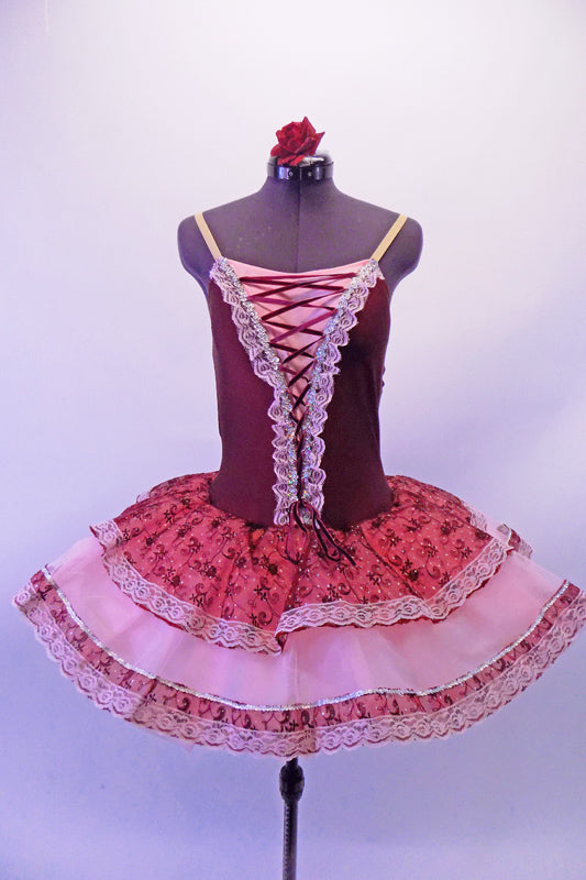 Sweet burgundy lycra bodice with corset lacing lace edged front has attached layered tutu skirt. The overlay is layers of pale pink and deep pink brocade edged with lace Comes with nude adjustable straps and floral hair accessory. Front