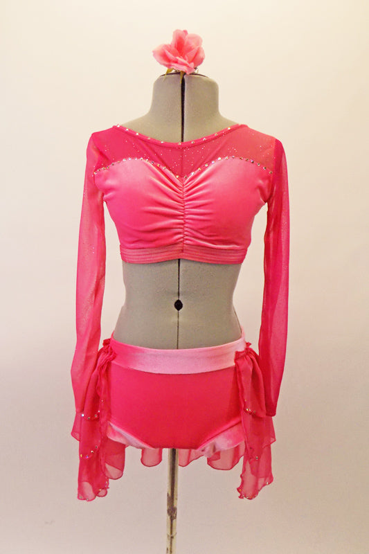 2-piece costume is a salmon pink half-top with long sparkle sheer sleeves, back & shoulders that compliment the crystalled velvet sweetheart cut of the bustline & keyhole back. The matching brief bottom has an attached triple layer, open front chiffon bustle shirt with crystal edged, Comes with a floral hair accessory. Front