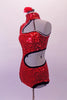 Spunky bright red sequined leotard has open left shoulder and side with swirled-circular design edged in black and lined entirely in Swarovski crystals. The asymmetrical back has a single crystal covered strap. Comes with a floral hair accessory. Left side