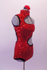 Spunky bright red sequined leotard has open left shoulder and side with swirled-circular design edged in black and lined entirely in Swarovski crystals. The asymmetrical back has a single crystal covered strap. Comes with a floral hair accessory. Right side