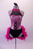 Fuchsia and black leotard has a pink animal print torso with faux corset detail and sweetheart bust lined entirely with crystals. The upper chest is a sheer black mesh with fuchsia collar.  The bustle gives the costume its biggest pop. It is comprised of layers of hot pink boa feathers. Comes with a floral hair accessory. Front
