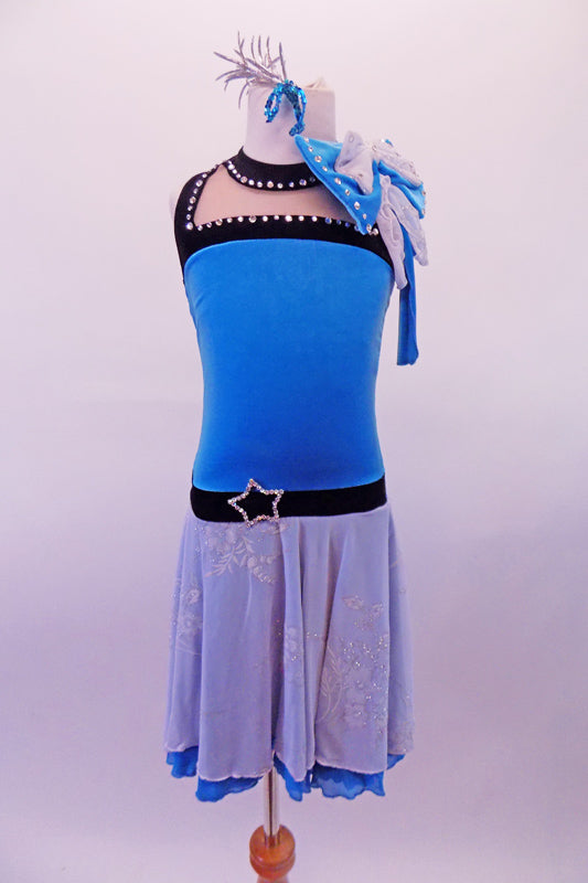 Blue velvet dress has black velvet bust & waist lined with crystals & a brooch accent at the waist. The double-layered blue and white floral chiffon skirt has a large bow accent at the right shoulder, accented with crystals. The back has wide “V” straps & a blue & white crystalled back bow. Comes with a hair accessory. Front
