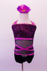 Sweet & classy short black unitard has purple band accents. The black velvet bust has purple sparkle swirl design & crystal-lined purple halter neck bands. The black sheer torso has crossed purple bands with velvet sides & crystal accents. The black velvet bottom finishes the outfit. Comes with a floral hair accessory. Front