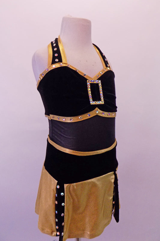 Black & gold dress is two pieces. The halter leotard has black velvet bust area edged with crystal covered gold piping, crystal brooch front accent & black sheer torso. The skirt bottom is a made of gold flaps with crystalled black edging. Comes with a black velvet bowler hat with gold band and crystal brooch accent. Front