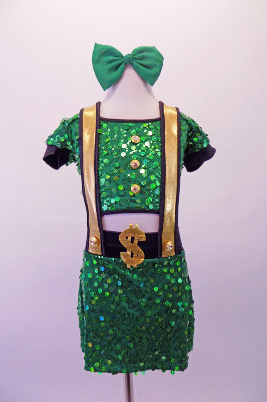 Green large sequined two-piece, money themed costume has half-top with cap sleeves and gold button front accents. The matching skort bottom has wide gold suspenders with black piping and money symbols at the back and waist front. Comes with a green bow hair accessory. Front