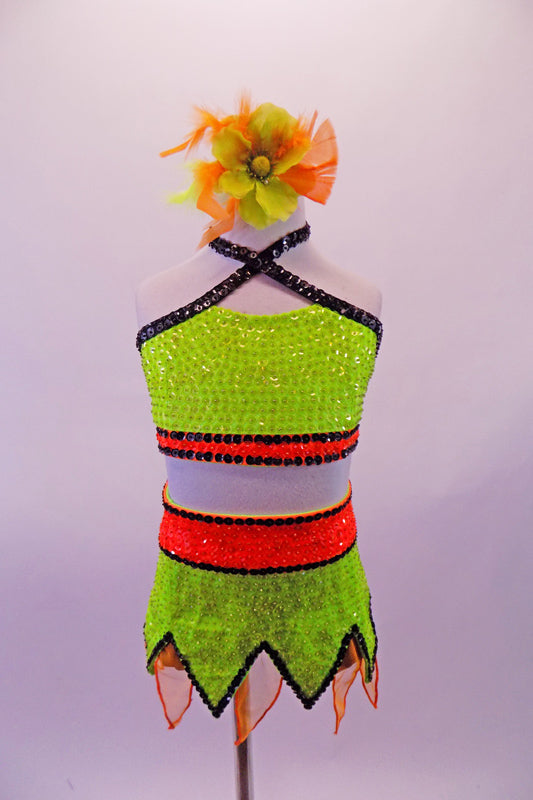 Neon green & orange two-piece costume is entirely made of beaded sequins. The green halter half top has black, cross front straps & orange bust band. The matching green sequined skirt has jagged edges with orange chiffon pieces & a wide orange sequined waistband. Comes with floral hair accessory & ankle/wristbands. Front