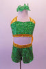 Two-piece costume is entirely green beaded sequin with gold sequin halter collar and banding. There is a large yellow organza bow with green sequin accents at the back of the shorts. Comes with green sequined hair bows. Front