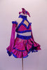 Two-piece costume is a magenta skirt with royal blue sequined ruffle trim and waistband and layered royal bluer ruffled petticoat. The matching top is a halter cut with a faux sweetheart cut with royal blue sequin banding that extends along the back. Comes with long gauntlets and a magenta bow hair accessory. Side