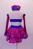 Two-piece costume is a magenta skirt with royal blue sequined ruffle trim and waistband and layered royal bluer ruffled petticoat. The matching top is a halter cut with a faux sweetheart cut with royal blue sequin banding that extends along the back. Comes with long gauntlets and a magenta bow hair accessory. Back