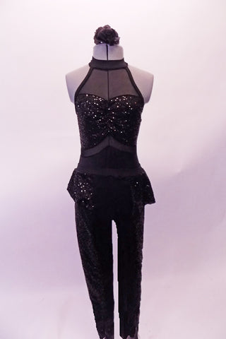 Black sequined full unitard has a mesh upper bust with halter neckline. The faux sweetheart neckline gathers at the center and accents the sheer black midriff.  The textured velvet legging style bottom has a sequined peplum at the waist. Comes with a black floral hair accessory. Front