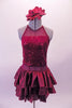 Deep burgundy halter neck leotard dress has a sequined torso. And sheer waist and ruffled layers of taffeta skirt. The open back has double vertical bands extending from the collar. Comes with a large burgundy floral hair accessory. Front